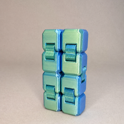 Cubo articulado verde e azul para manipulação tátil