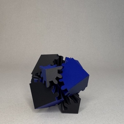 Puzzle tridimensional azul e preto sobre fundo cinzento