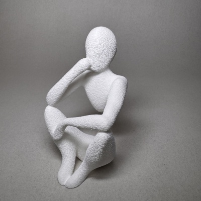 Escultura abstrata branca em forma humana sentada com textura, fundo cinzento.