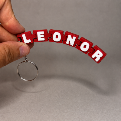 Porta-chaves vermelho com letras brancas formando LEONOR