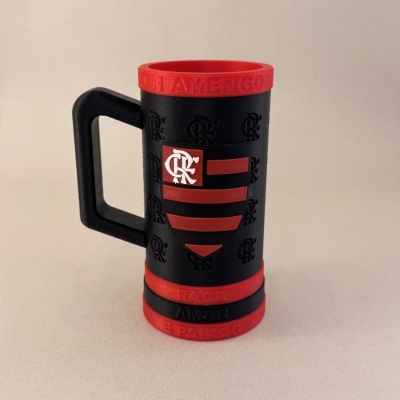 Caneca preta com detalhes vermelhos e texto em relevo FLAMENGO na borda superior.