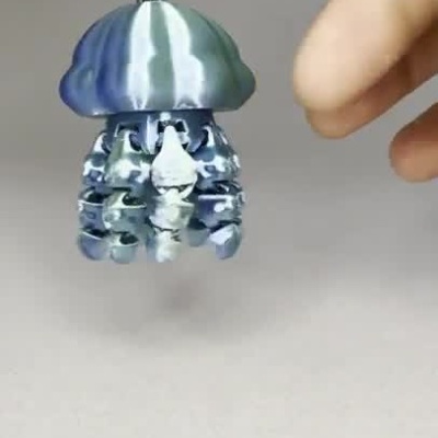 Chaveiro metálico em forma de água-viva azul com tentáculos camuflados pendurados