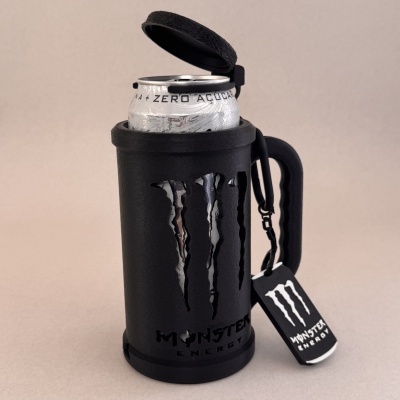 Porta-lata preto com logotipo Monster Energy contendo lata prateada de bebida energética zero açúcar e etiqueta pendurada