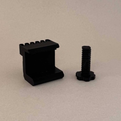 Peças pretas em plástico ou metal sobre superfície bege.