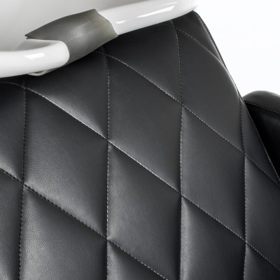 Encosto de cadeira em couro sintético preto com padrão em losangos e estrutura branca.