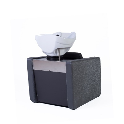 Cadeira de lavagem para salão com lavatório branco e estofos cinzentos.