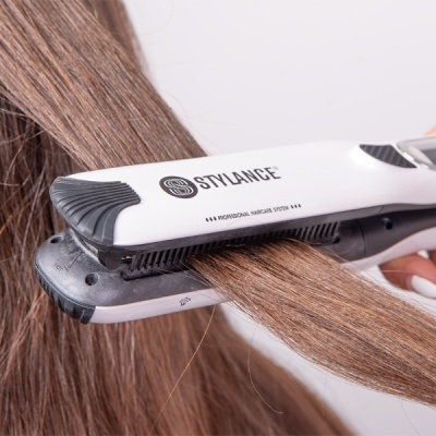 Prancha de cabelo branca e preta STYLANCE a alisar cabelo castanho
