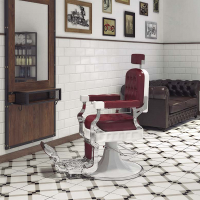 Cadeira de barbeiro vintage vermelha e cromada numa sala com chão de azulejos geométricos