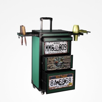 Carrinho verde com rodas e puxador, gavetas com placas de matrícula e suporte para secador e escovas