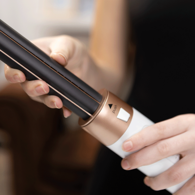 Dispositivo de alisador de cabelo preto e dourado com botão PUSH