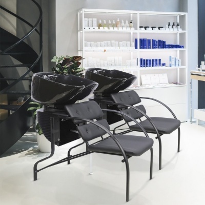 Cadeiras pretas com pias de lavagem, estante com produtos em salão moderno