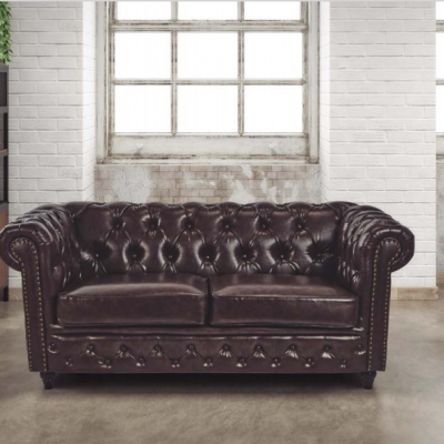 Sofá Chesterfield de couro castanho escuro em ambiente industrial