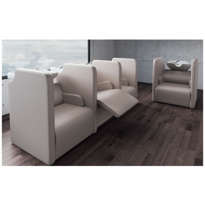 Três poltronas de couro bege claro em ambiente moderno com chão de madeira escura