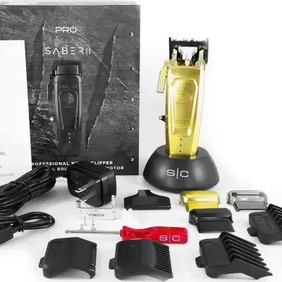 Máquina de cortar cabelo dourada marca PRO SABER II com acessórios e manual sobre fundo branco