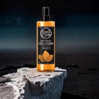 Frasco laranja de perfume Red One sobre rocha clara em cenário escuro