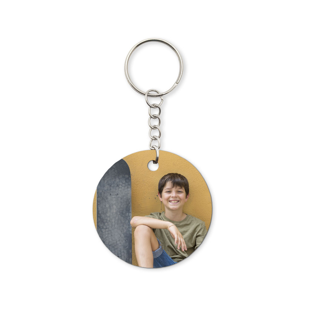Chaveiro redondo com foto de rapaz sorridente sentado