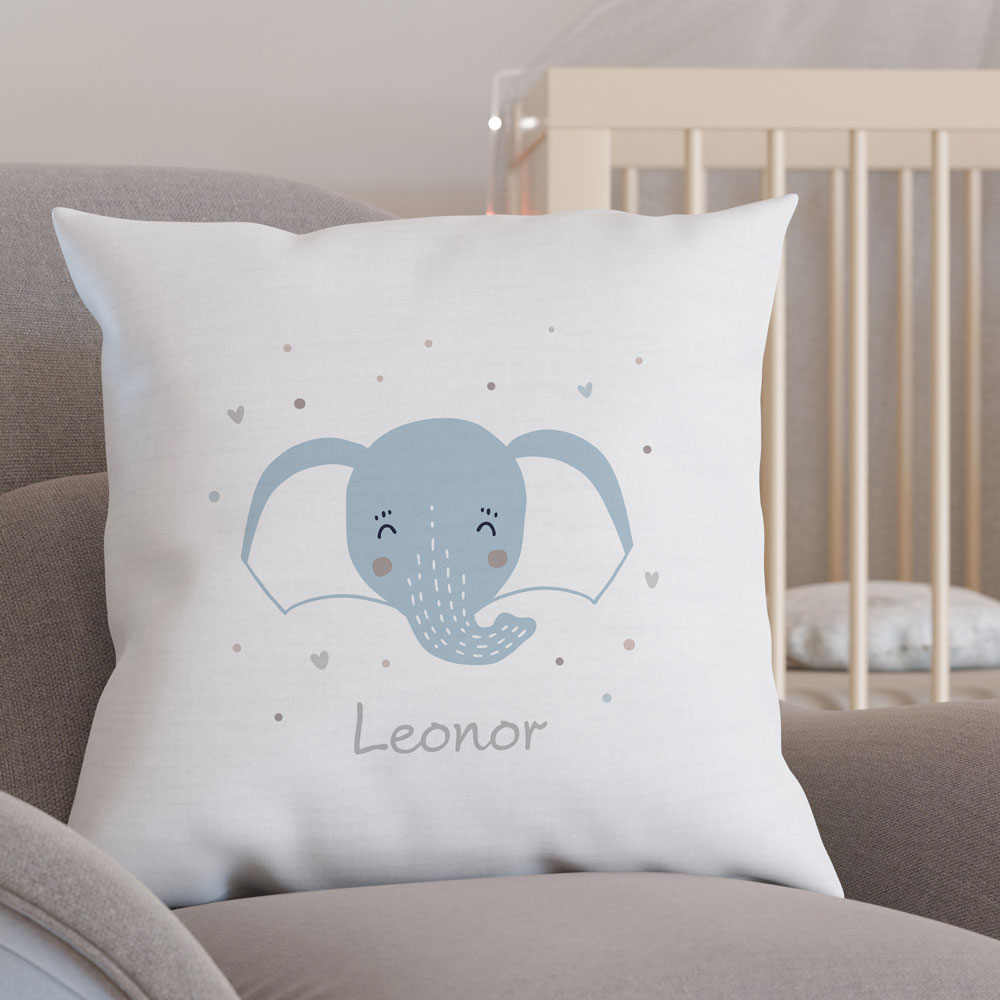 Almofada branca com elefante azul e nome Leonor numa poltrona cinzenta