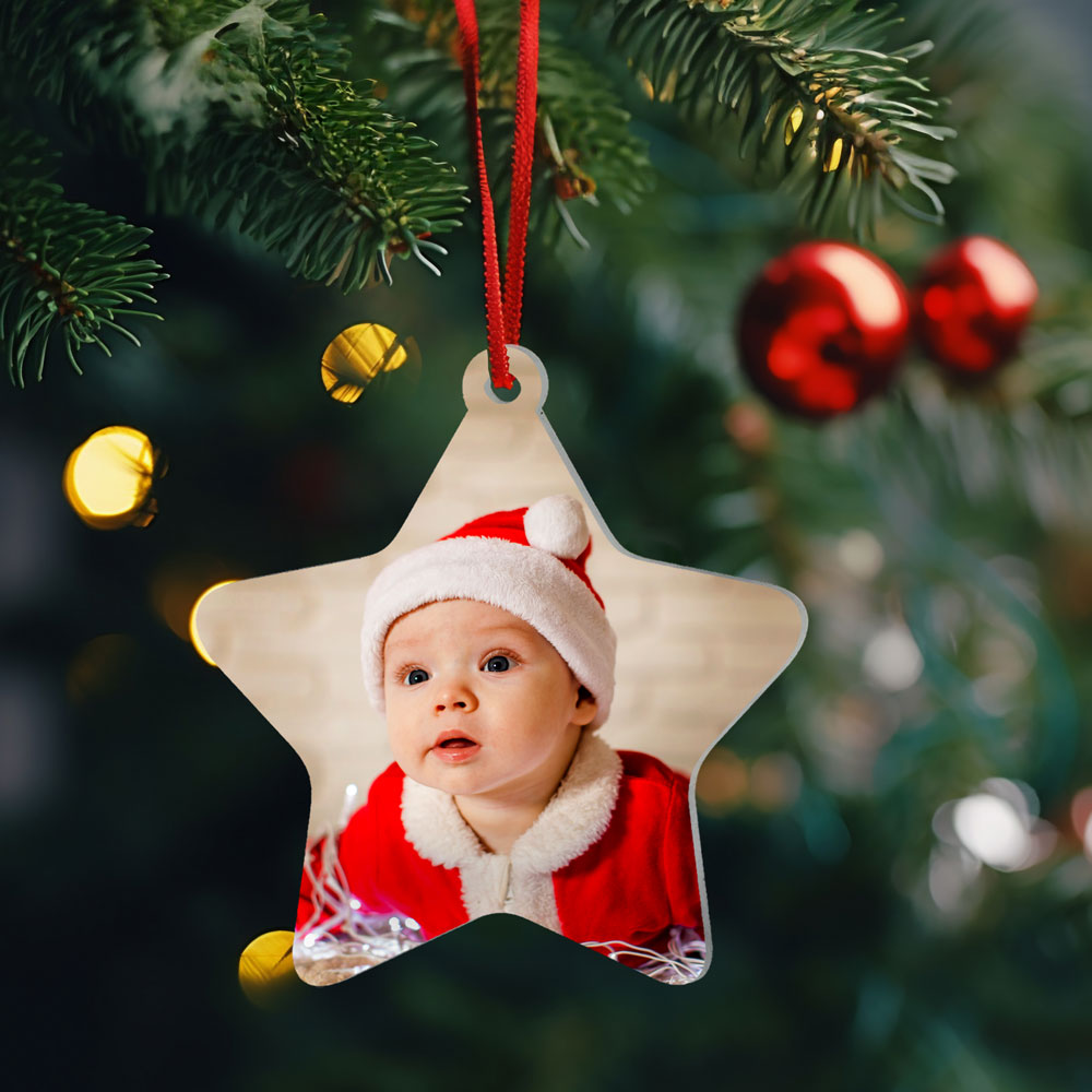 Enfeite de Natal em estrela com foto de bebé vestido de Pai Natal pendurado em árvore