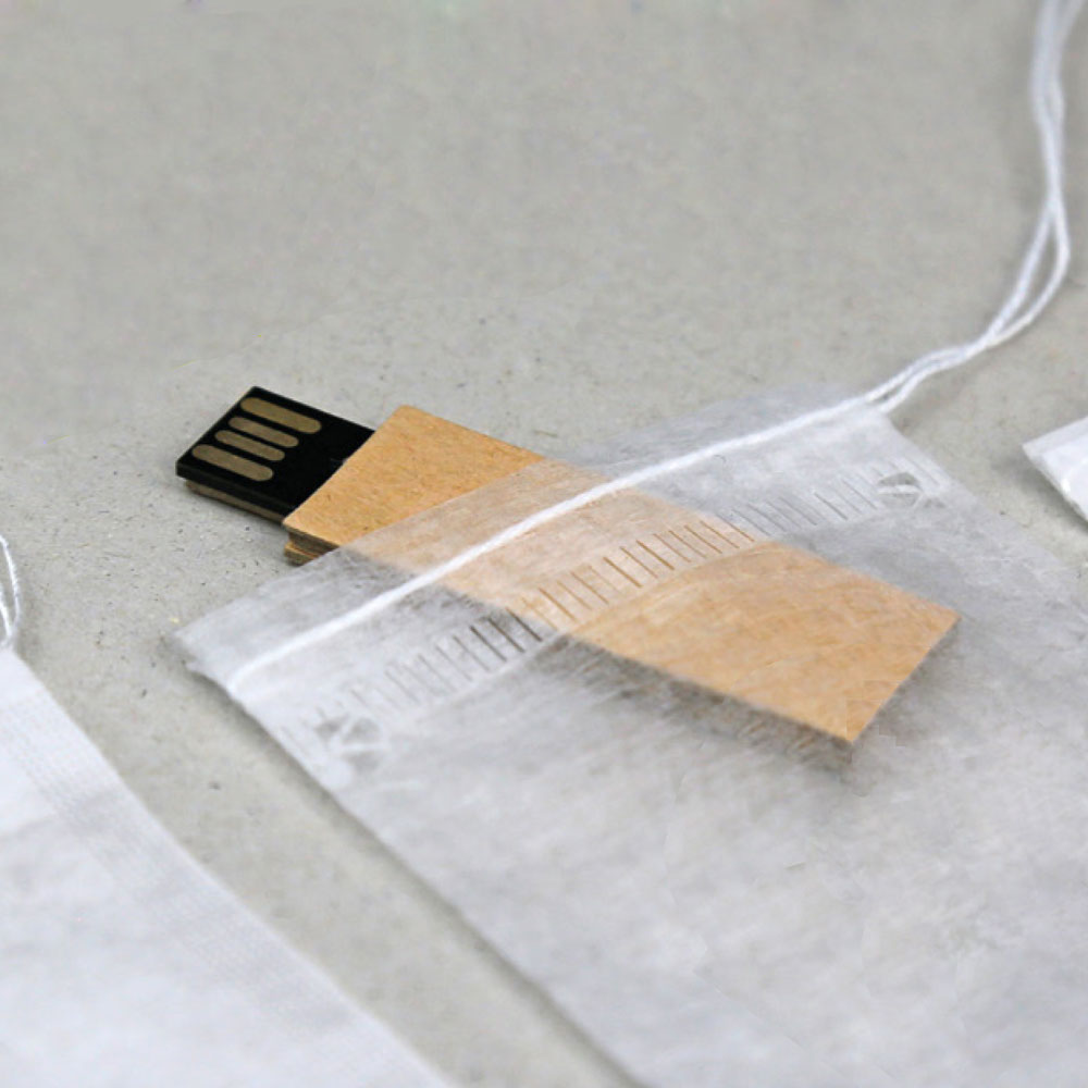 Pen USB em cartão castanho dentro de saco de organza branco