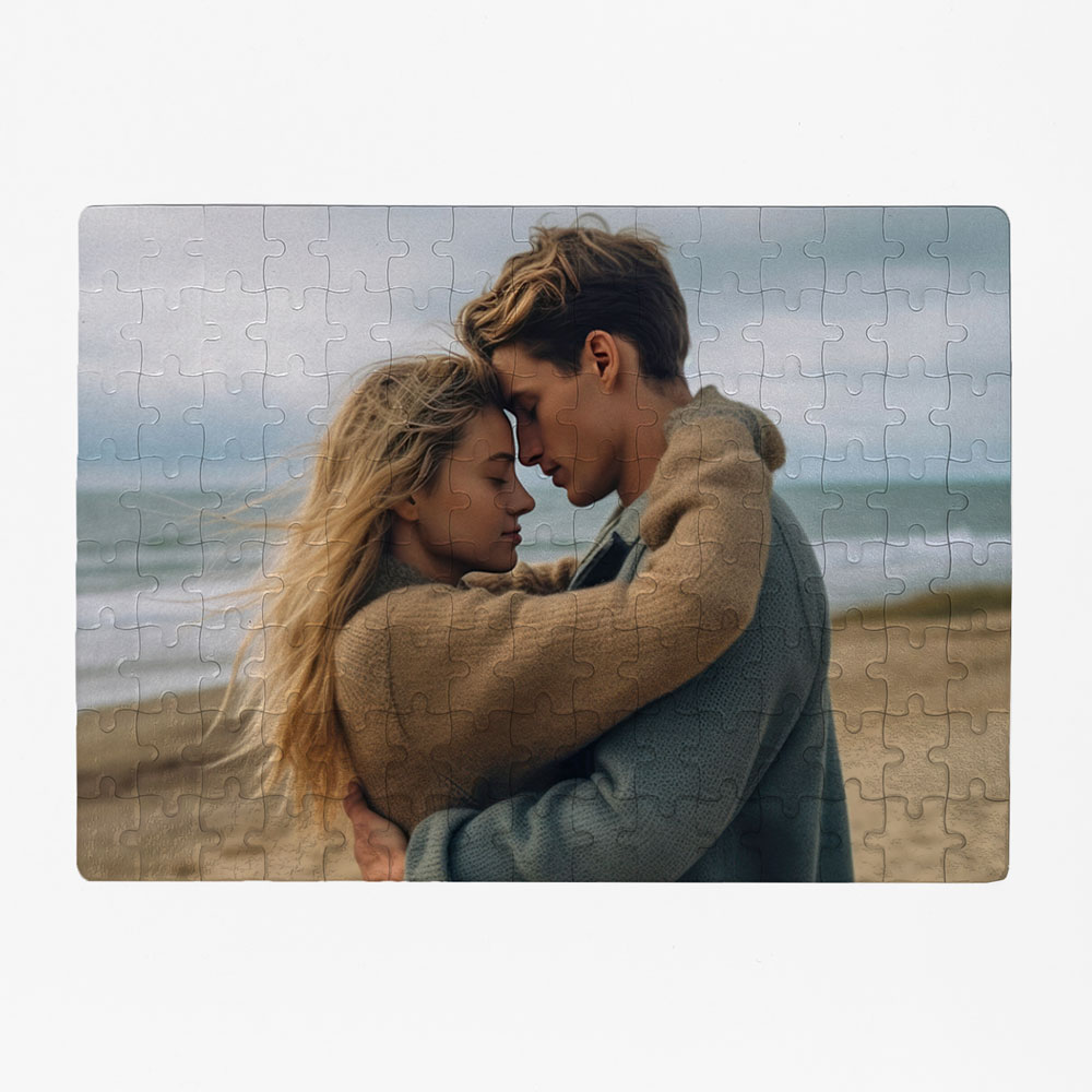 Puzzle com imagem de casal jovem abraçado numa praia com mar ao fundo