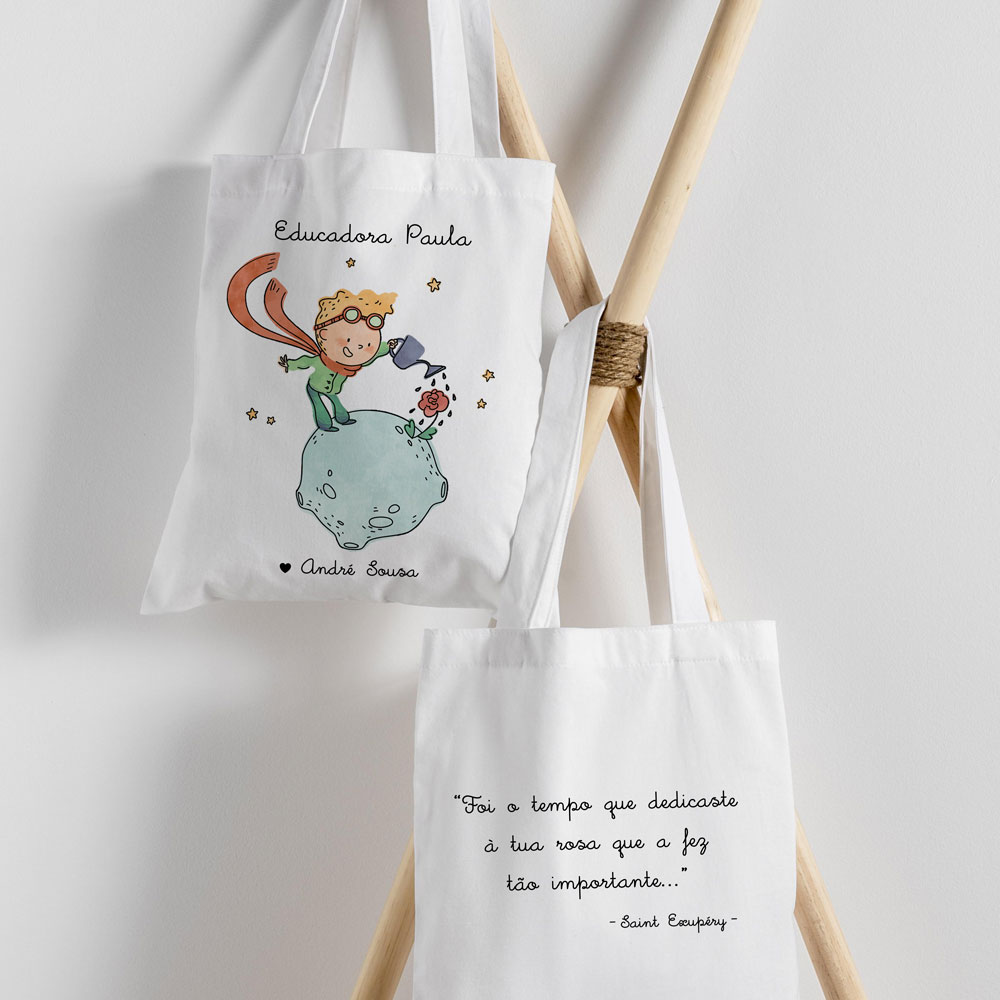 Dois sacos de pano brancos com texto e ilustração pendurados em suporte de madeira