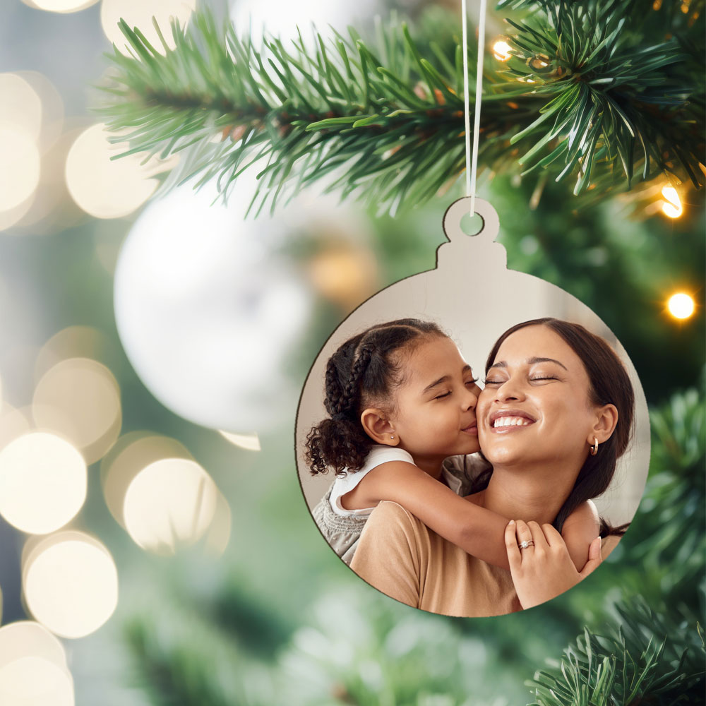 Ornamento redondo prateado com fotografia pendurado em árvore de Natal
