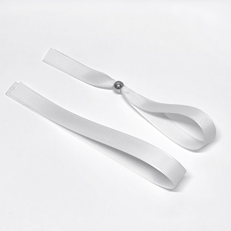 Duas fitas brancas texturizadas com esfera metálica prateada numa sobre fundo branco