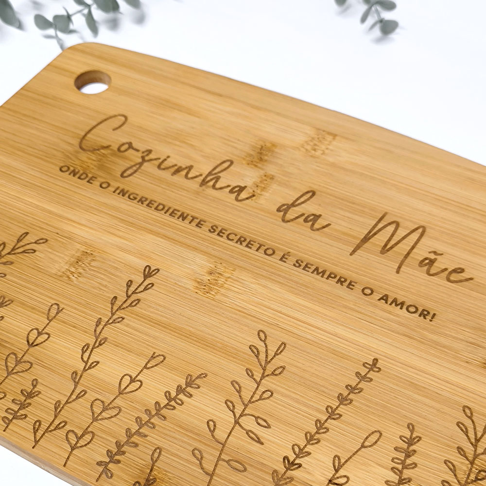 Tábua de corte em madeira clara com texto e desenhos gravados
