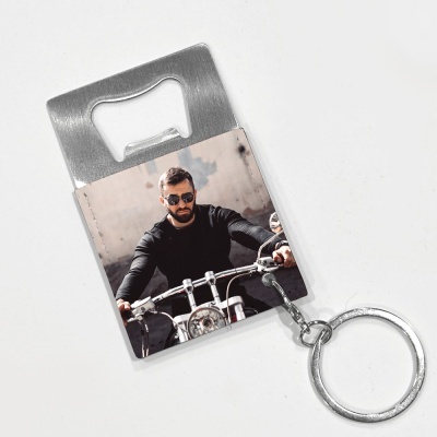 Abridor de garrafas metálico com chaveiro e imagem de homem numa mota