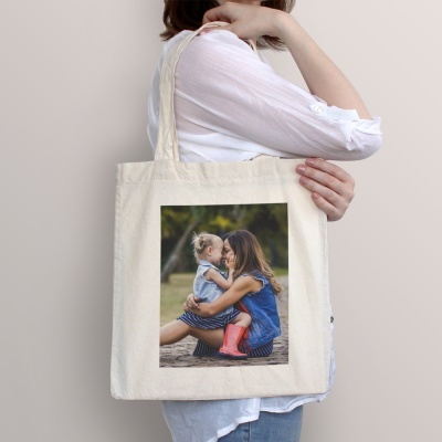 Sacola de tecido creme com impressão de mulher e menina sentadas ao ar livre