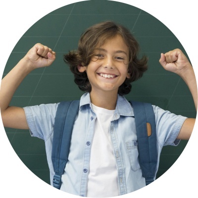 Criança sorridente com mochila e roupas casuais em frente a quadro verde