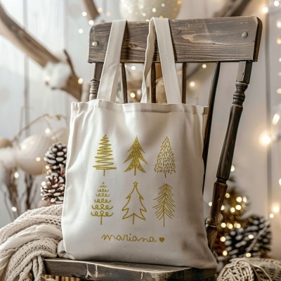 Saco de tecido branco com árvores de Natal douradas pendurado numa cadeira de madeira escura