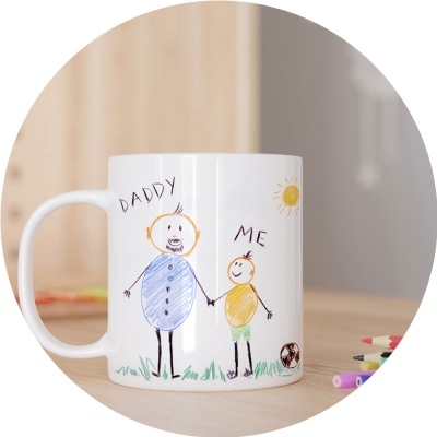 Caneca branca com desenho infantil de pai e filho, sol e bola de futebol, sobre mesa de madeira
