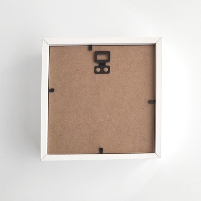 Moldura quadrada branca vista de trás com suporte e presilhas pretas