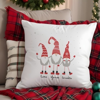 Almofada branca com três duendes natalícios desenhados e nomes, em sofá com mantas e almofadas xadrez e decoração de Natal