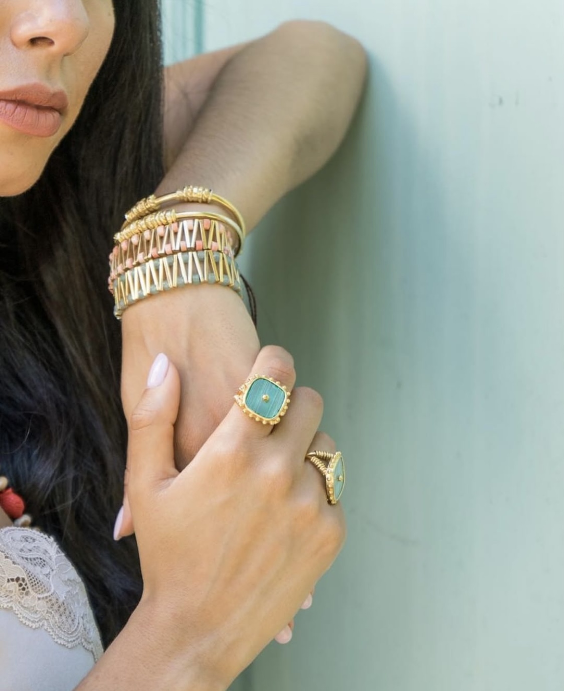 Couleurs D`Argent Pulseira prata 925%, com Angelite. Anéis e pulseiras douradas com pedras verde e elementos salmão na mão e braço de uma mulher.