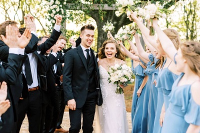 Noivos e convidados em casamento ao ar livre com vestuário formal e buquê de flores