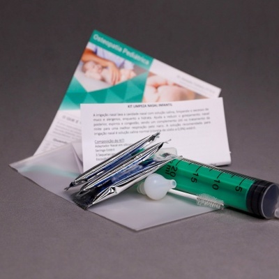 Syringe green with needles and informational leaflets on gray surface