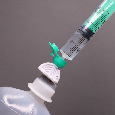 Seringa verde na tampa de frasco plástico