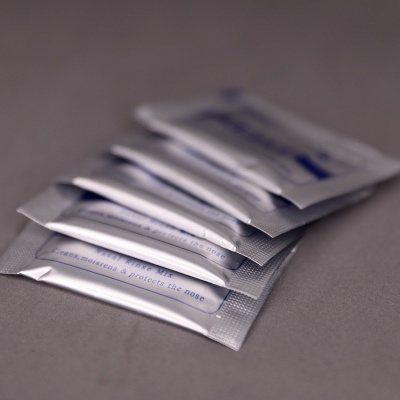 Cinco saquetas individuais cinzentas dispostas em superfície cinza