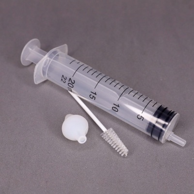 Seringa plástica transparente de 20 ml com escova branca e tampa, fundo cinza
