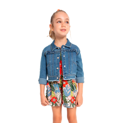 Menina com casaco de ganga azul e vestido floral colorido.