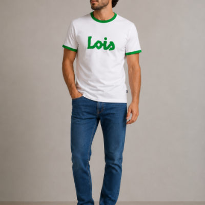 Homem com t-shirt branca e verde Lois, jeans azuis e sapatilhas brancas em fundo cinza