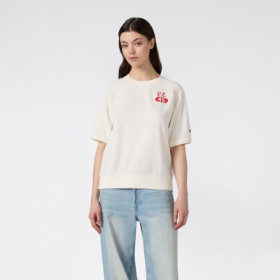Pessoa com camisola creme P.E 45 e calças de ganga largas azul claro rasgadas