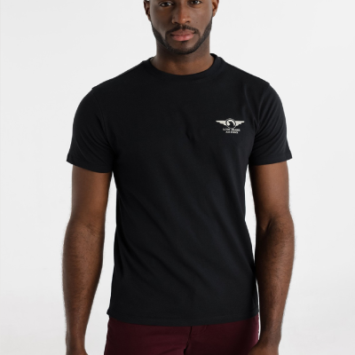 Homem com t-shirt preta com logótipo LOIS JEANS AIR FORCE e calças bordeaux