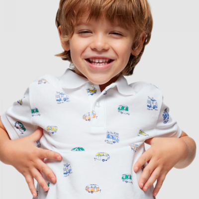 Camisola polo branca para criança com padrão de pequenas caravanas coloridas e textos relacionados a estrada.