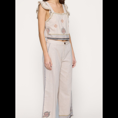 Conjunto feminino bege com padrão floral, top com folhos nas alças, calças largas e sandálias rasas castanhas