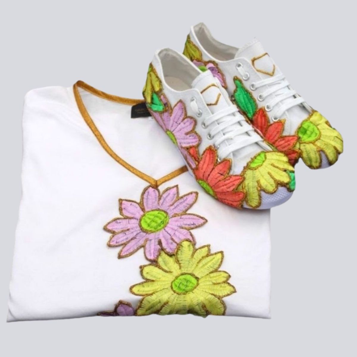 Conjunto Margaridas Sapatilhas brancas com bordados florais coloridos e peça de roupa branca com bordados similares