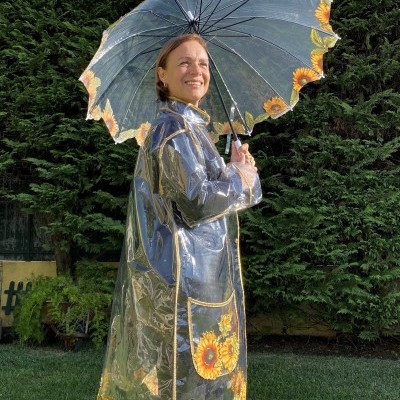 Capa de chuva transparente com padrão de girassóis e guarda-chuva combinando no jardim