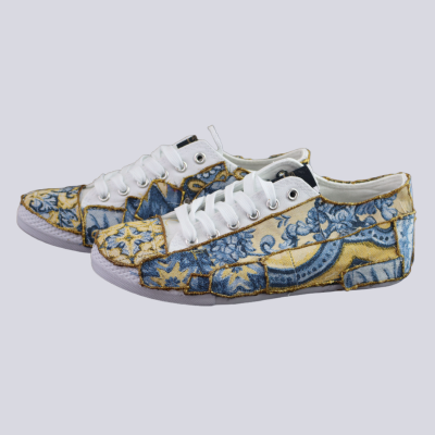 Sapatilhas baixas coloridas com padrão azul e amarelo, atacadores brancos e sola branca